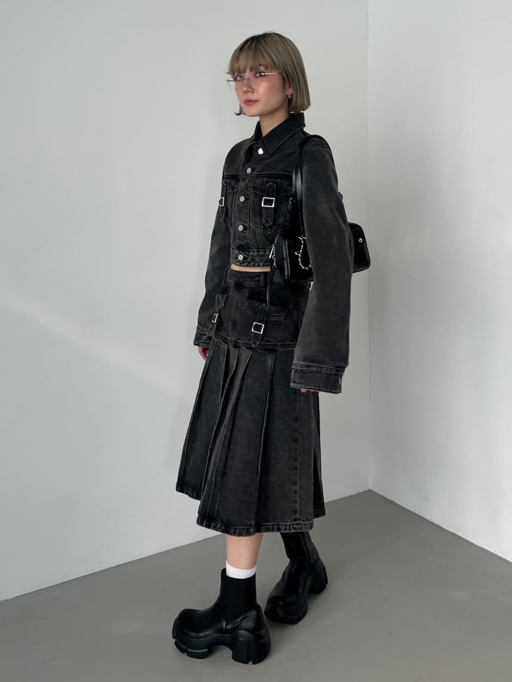 ブラック系のブーツ、ブラック系のデニムスカート、ブラック系のデニムジャケットを着用したレディースの秋コーディネートの2枚目の写真