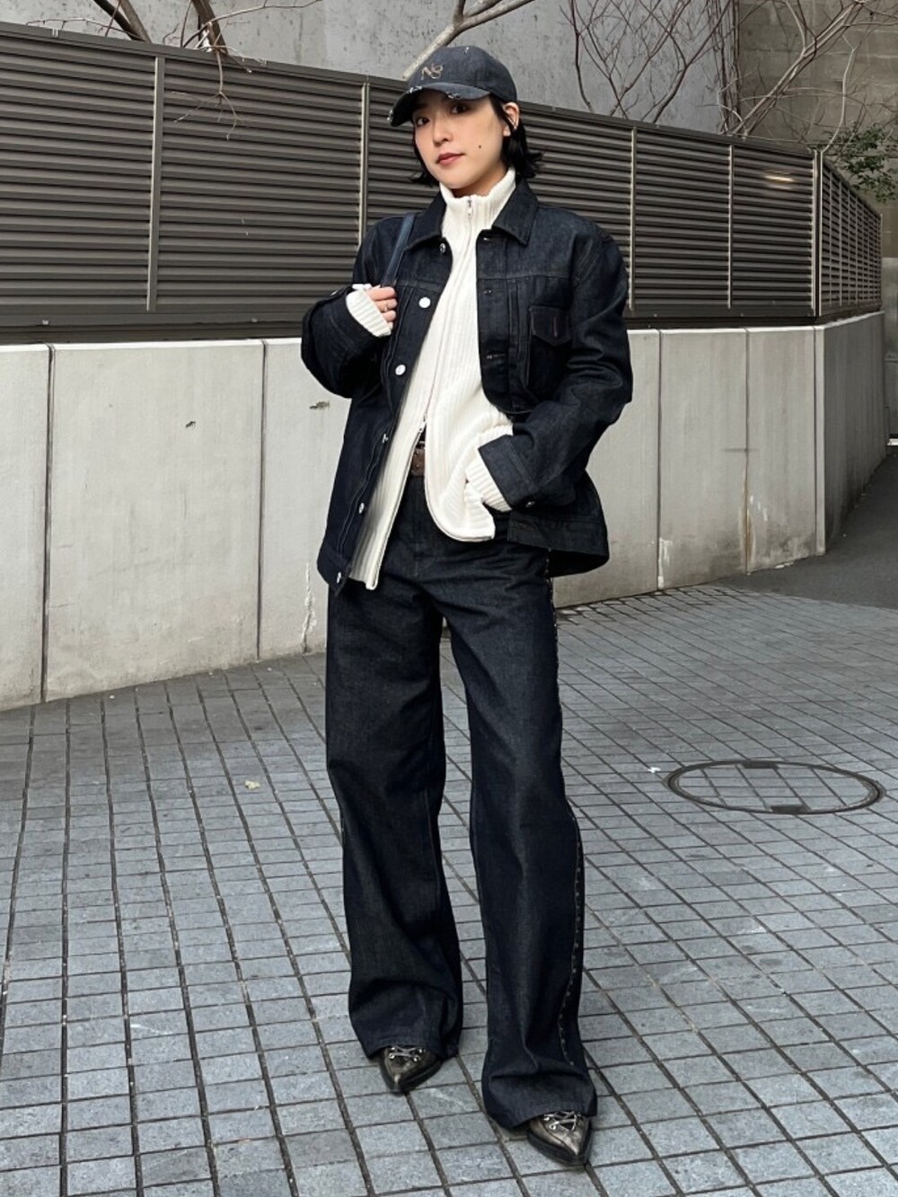 ブラック系のハンドバッグ、ブルー系のデニムパンツ、ブルー系のデニムジャケットを着用したレディースの冬コーディネートの2枚目の写真