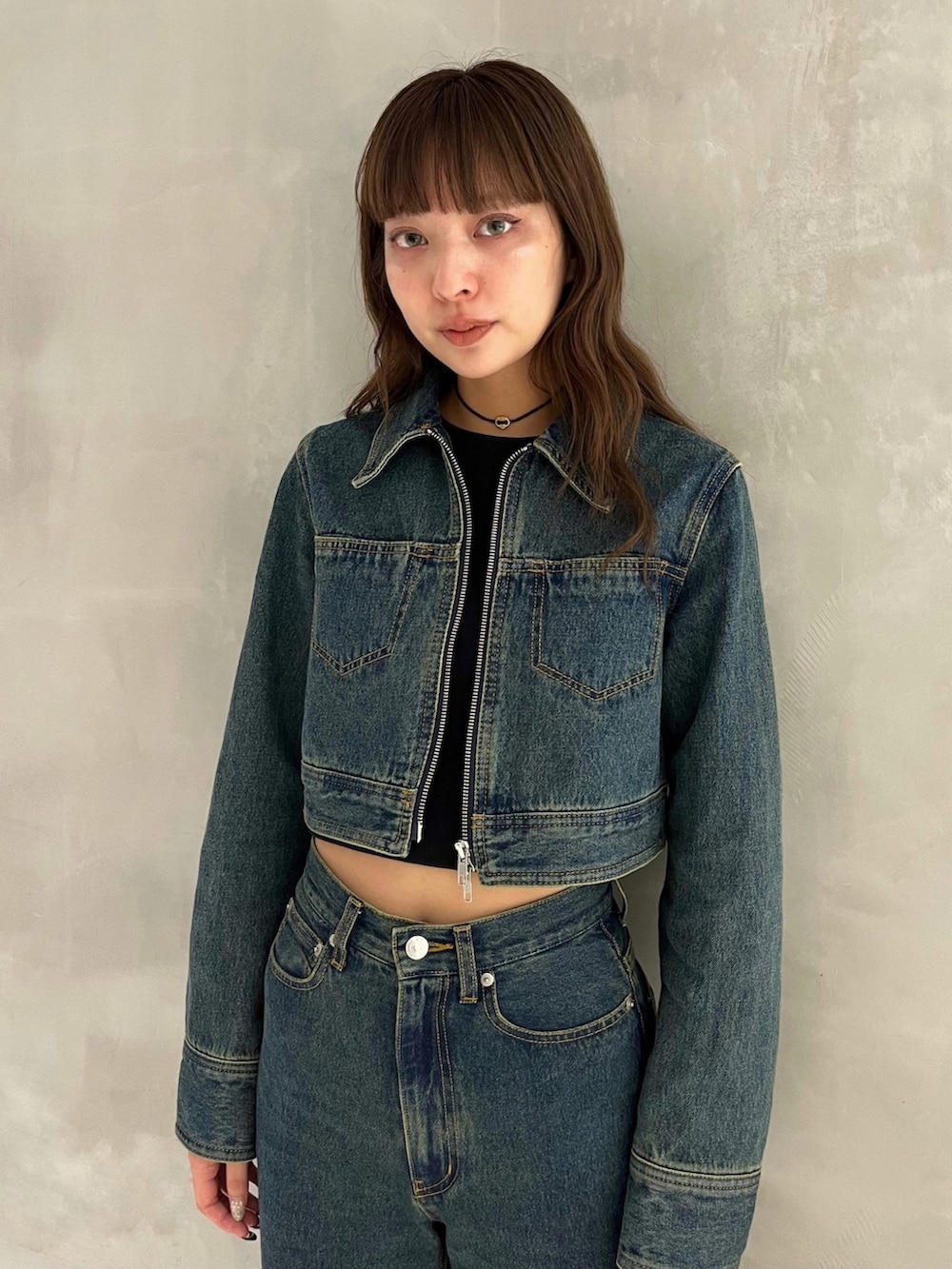 ブルー系のデニムパンツ、ブラック系のサンダル、ブルー系のデニムジャケットを着用したレディースの秋コーディネートの2枚目の写真