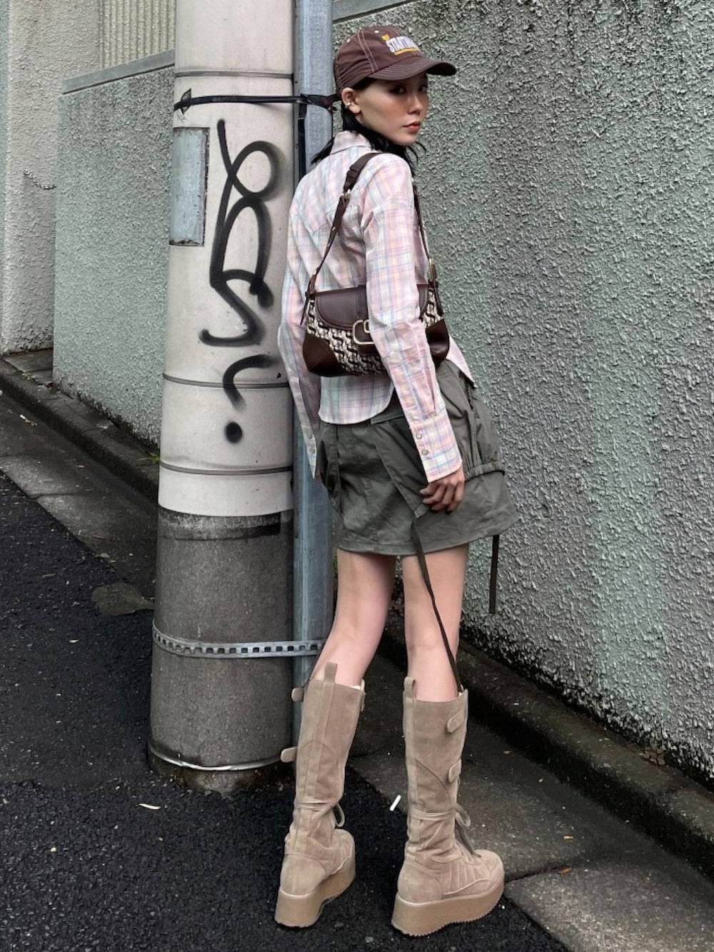 グリーン系のスカート、ピンク系のシャツ/ブラウス、ベージュ系のブーツを着用したレディースの春コーディネートの2枚目の写真