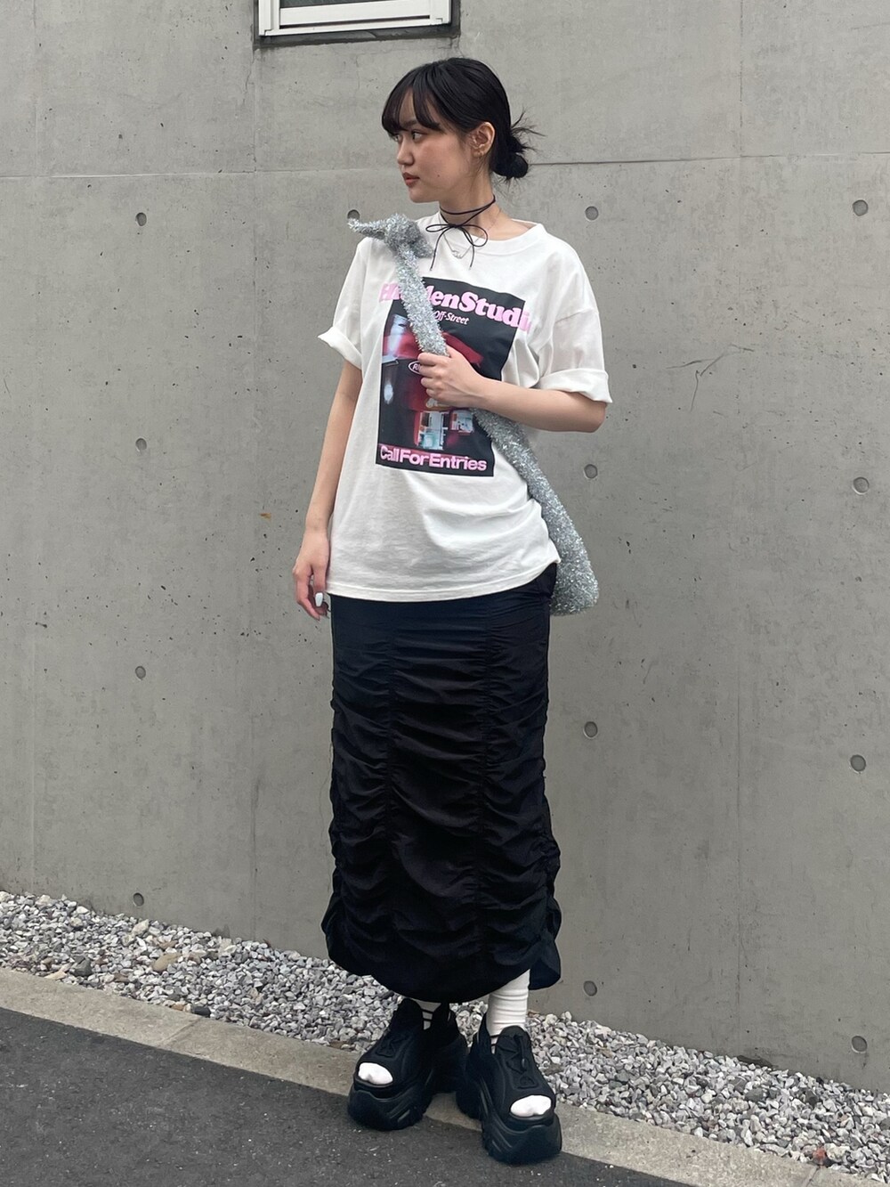 ホワイト系のTシャツ/カットソー、シルバー系のショルダーバッグ、ブラック系のスカートを着用したレディースの春コーディネートの2枚目の写真