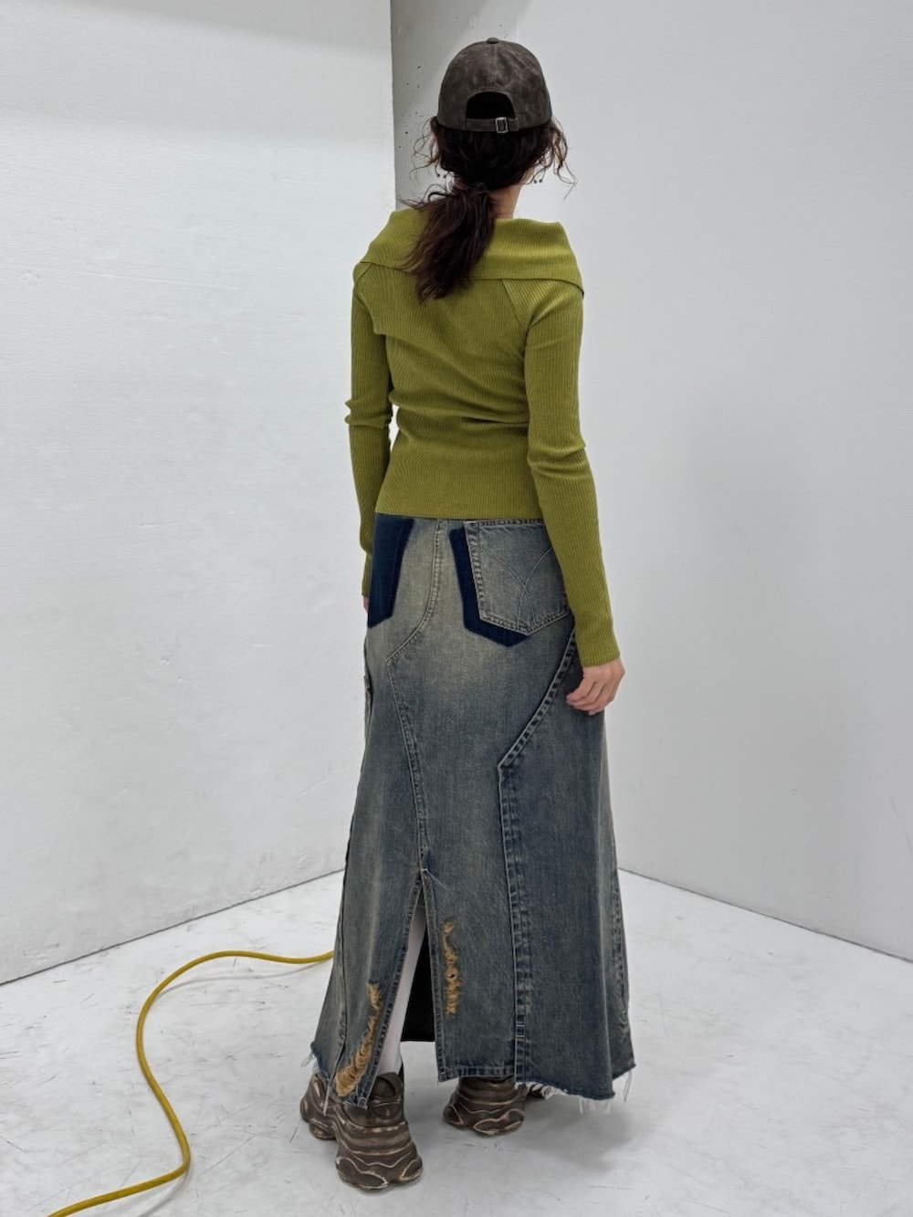 ブラウン系のスニーカー、ブルー系のデニムスカート、ブラウン系のキャップを着用したレディースの春コーディネートの2枚目の写真