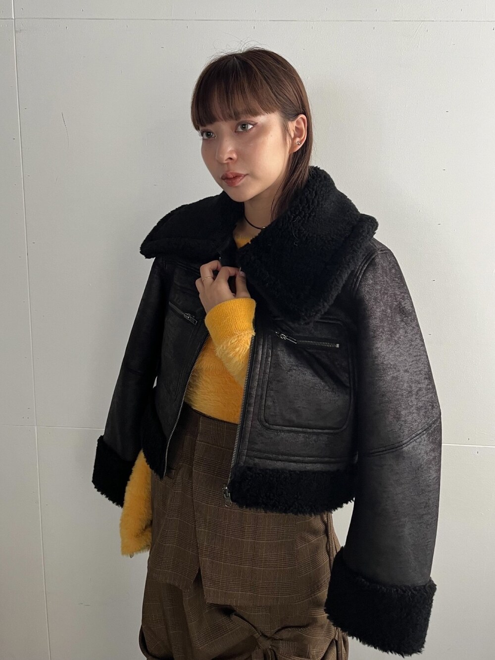 ブラック系のブルゾン、イエロー系のニット/セーター、その他のスカートを着用したレディースの秋コーディネートの2枚目の写真