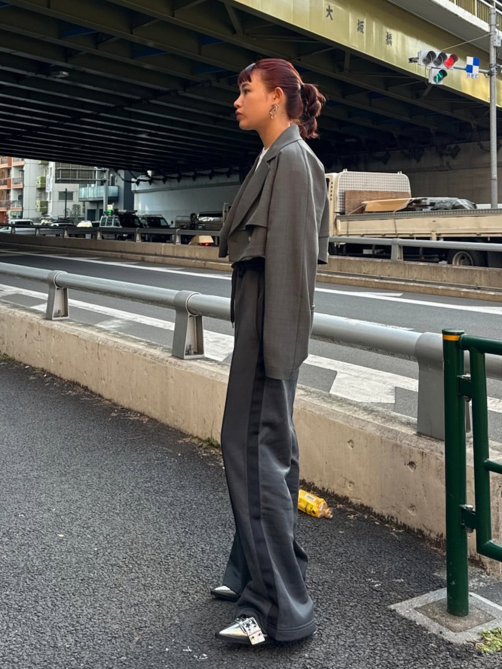 グレー系のトレンチコート、ホワイト系のTシャツ/カットソー、ブラック系のスラックスを着用したレディースの冬コーディネートの3枚目の写真