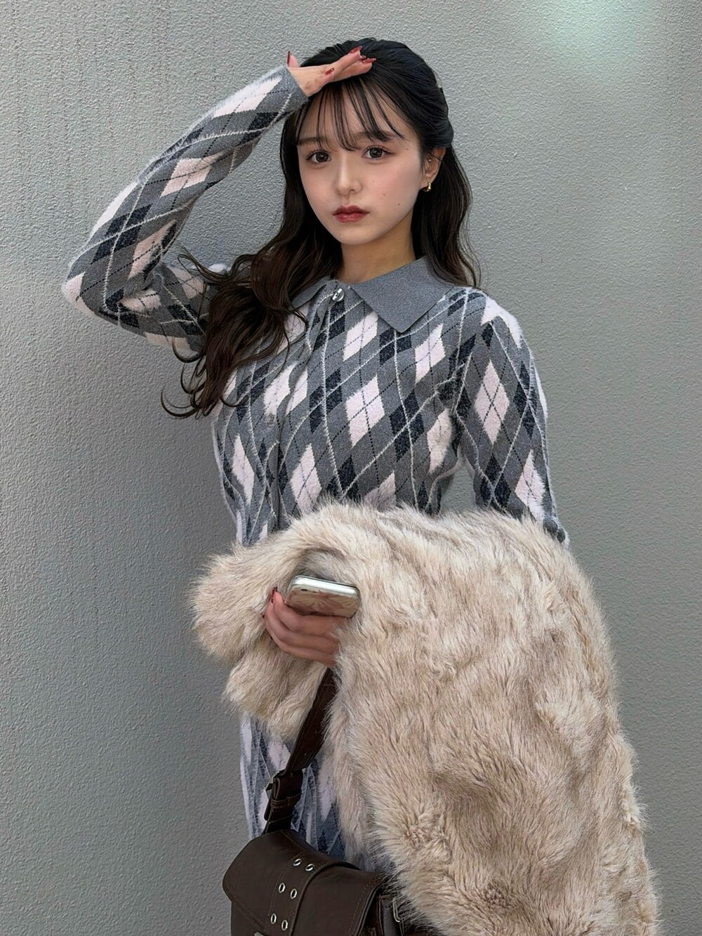 グレー系のカーディガン/ボレロ、グレー系のスカート、ブラウン系のハンドバッグを着用したレディースの秋コーディネートの3枚目の写真