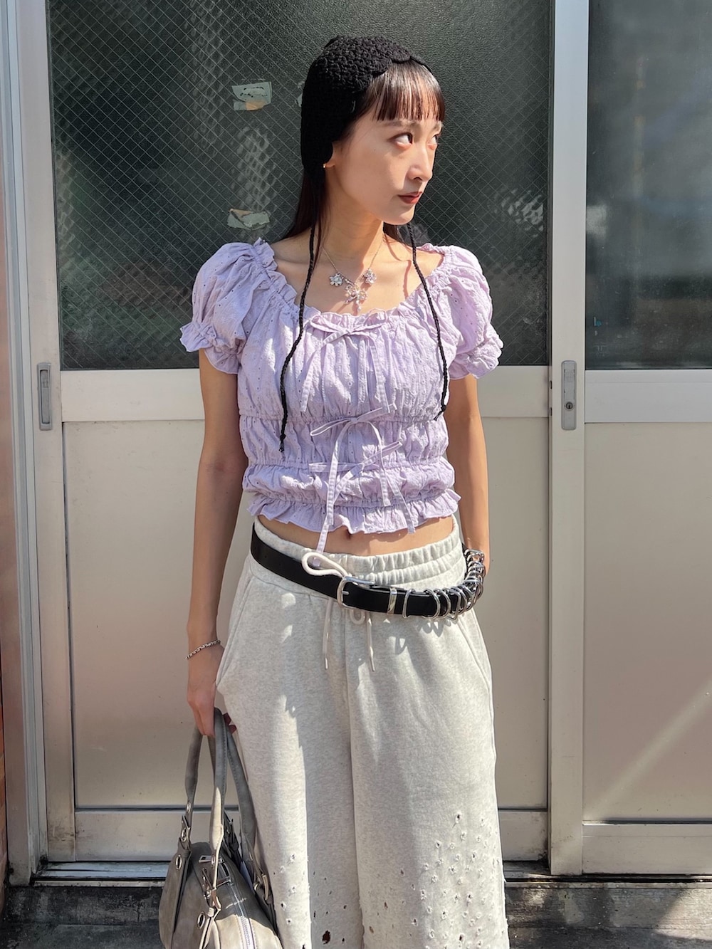 グレー系のハンドバッグ、グレー系のスウェットパンツ、パープル系のシャツ/ブラウスを着用したレディースの夏コーディネートの4枚目の写真