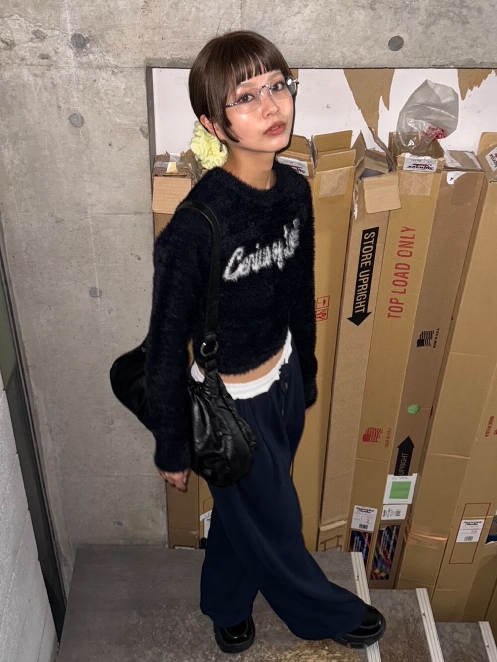 ブラック系のニット/セーター、ブルー系のスラックス、シルバー系のサングラスを着用したレディースの秋コーディネートの4枚目の写真