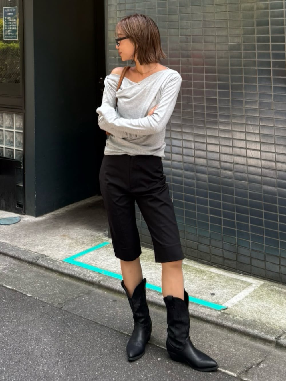 グレー系のTシャツ/カットソー、ブラック系のスラックスを着用したレディースの夏コーディネートの3枚目の写真