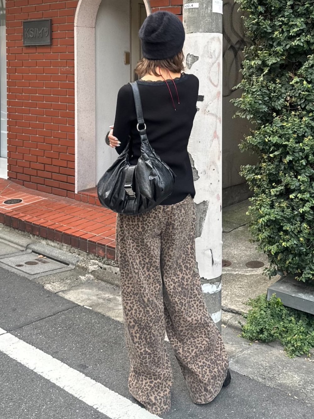 ブラウン系のデニムパンツ、ブラック系のニット/セーター、ブラック系のブーツを着用したレディースの夏コーディネートの3枚目の写真