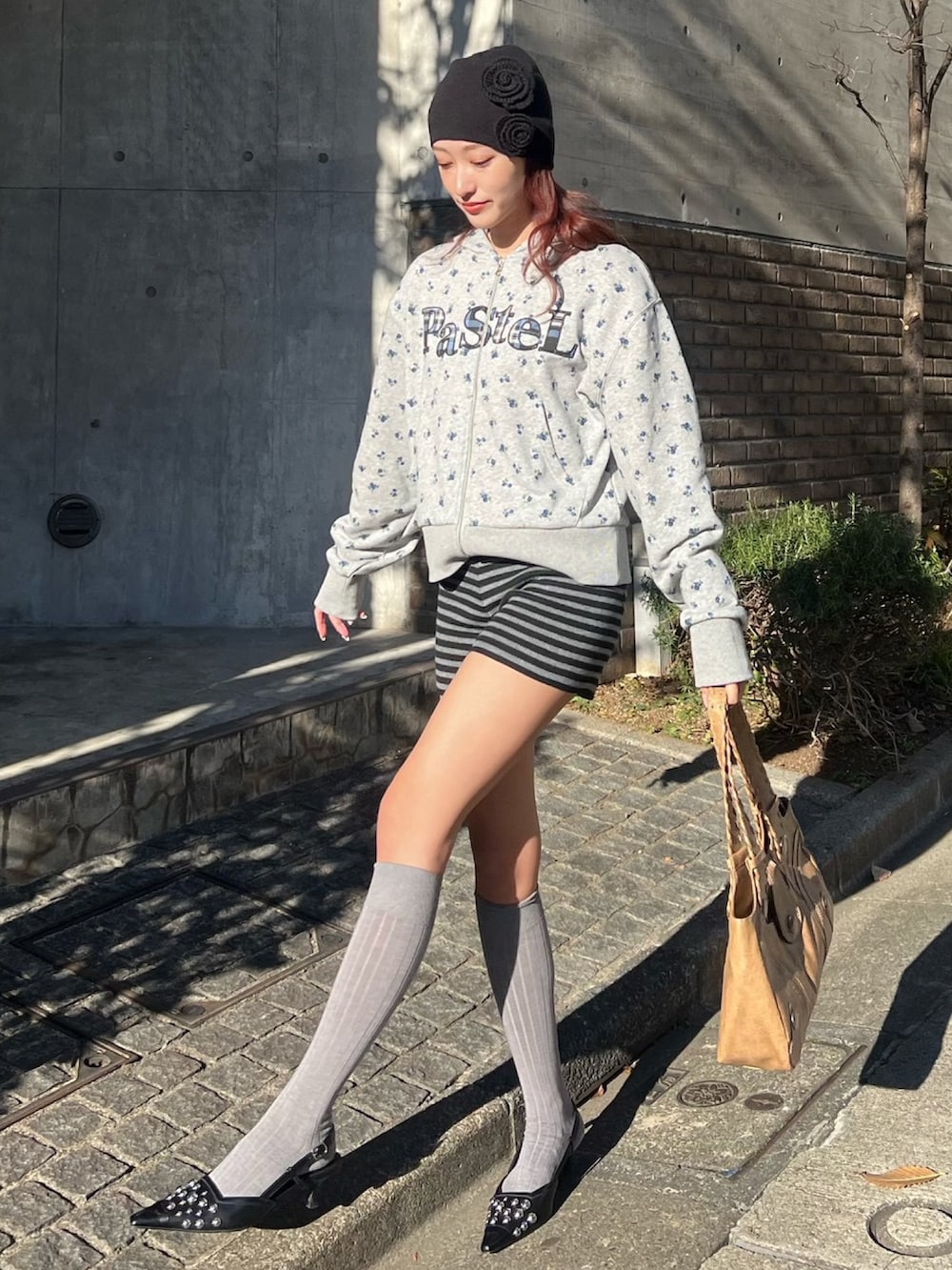 グレー系のパーカー、ブラック系のスラックス、ブラック系のサンダルを着用したレディースの冬コーディネートの2枚目の写真