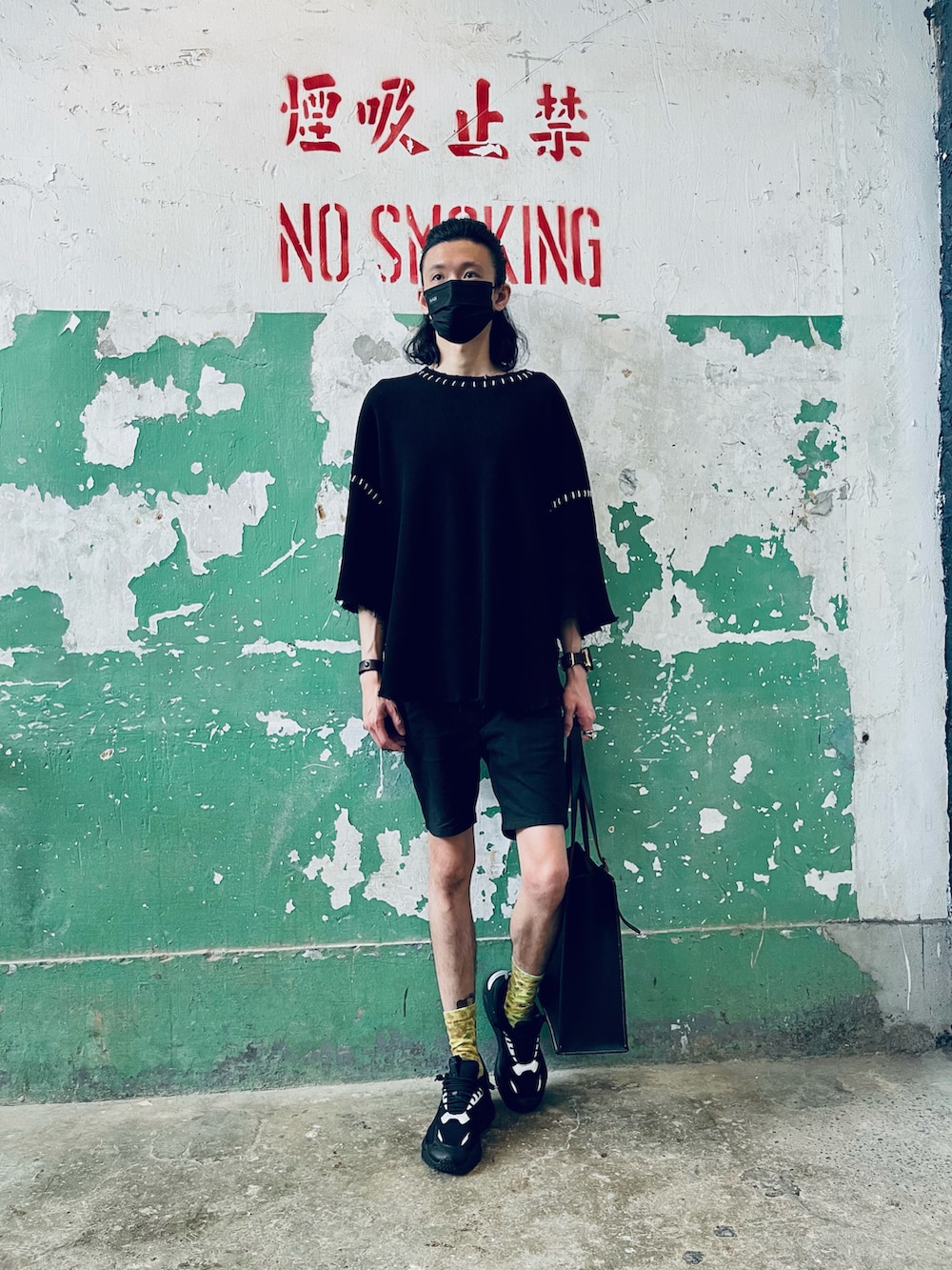 ブラック系のTシャツ/カットソー、ブラック系のスニーカー、グリーン系のトートバッグを着用したメンズの夏コーディネートの2枚目の写真