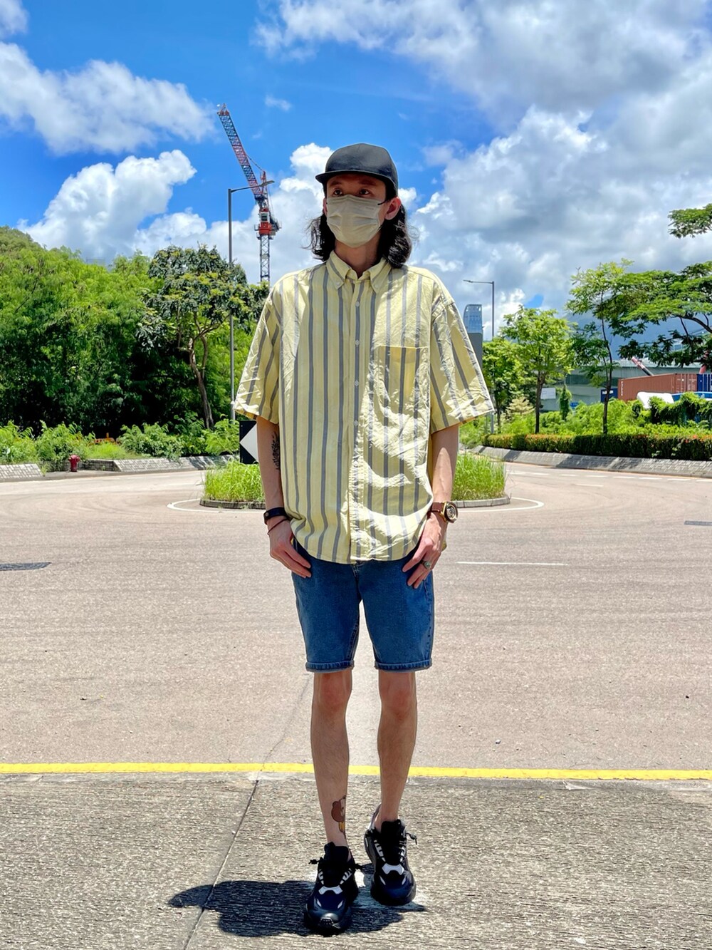 イエロー系のシャツ/ブラウス、ブルー系のデニムパンツ、ブラック系のスニーカーを着用したメンズの夏コーディネートの2枚目の写真