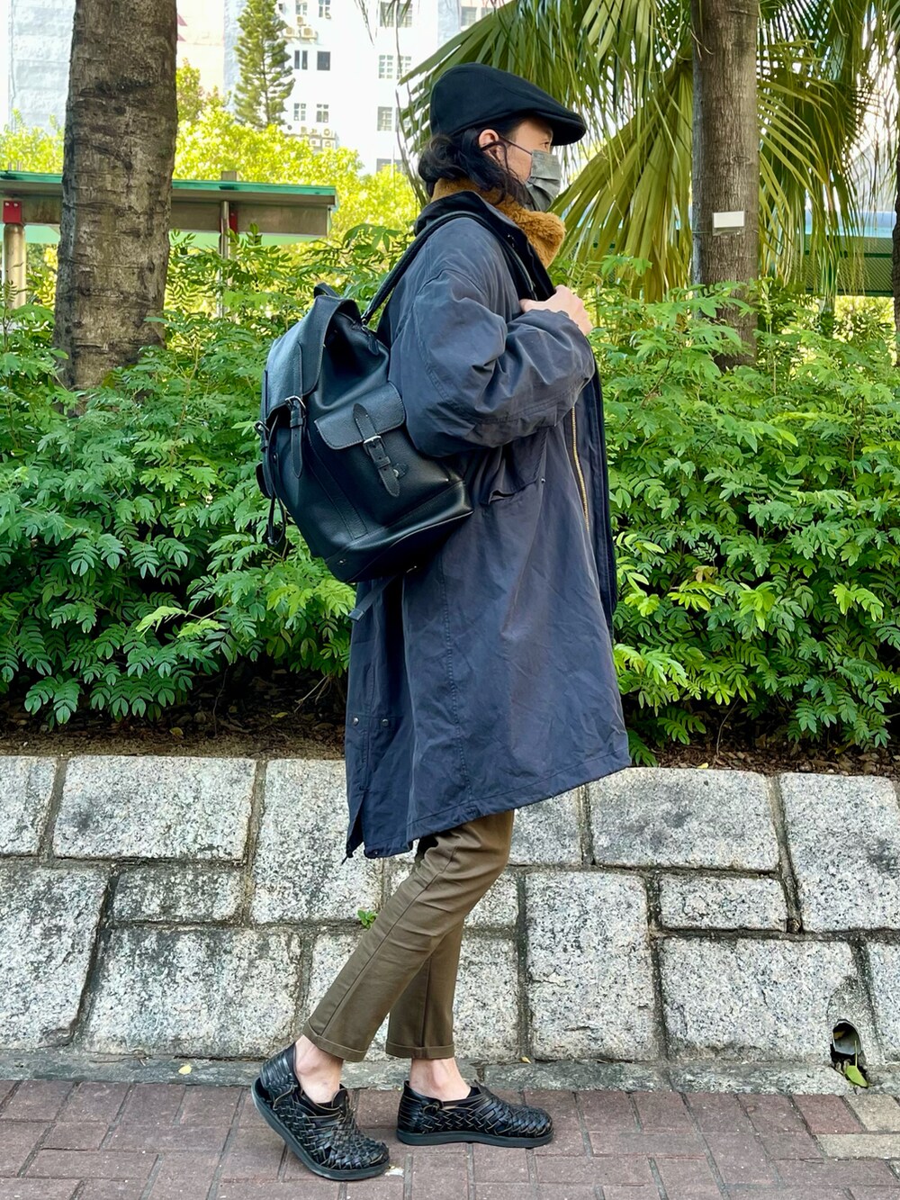 ブラック系のマウンテンパーカー、ブラウン系のスウェット、グリーン系のチノパンツを着用したメンズの春コーディネートの2枚目の写真