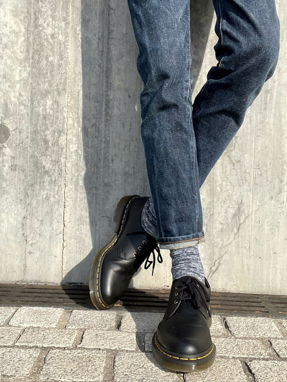 ブラック系のミリタリージャケット、ブルー系のデニムパンツ、ブラック系のその他シューズを着用したメンズの春コーディネートの4枚目の写真