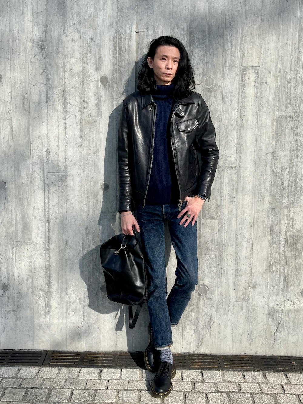 ブラック系のミリタリージャケット、ブルー系のデニムパンツ、ブラック系のその他シューズを着用したメンズの春コーディネートの2枚目の写真