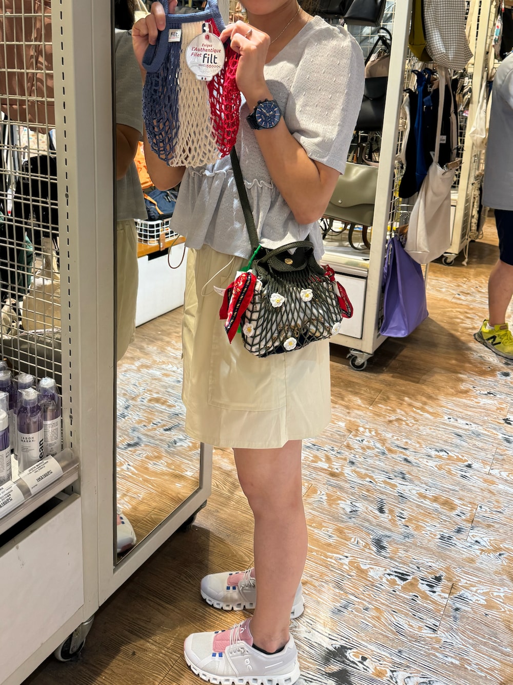 ブルー系のトップス、グリーン系のバッグ、ベージュ系のスカートを着用したレディースの秋コーディネートの2枚目の写真