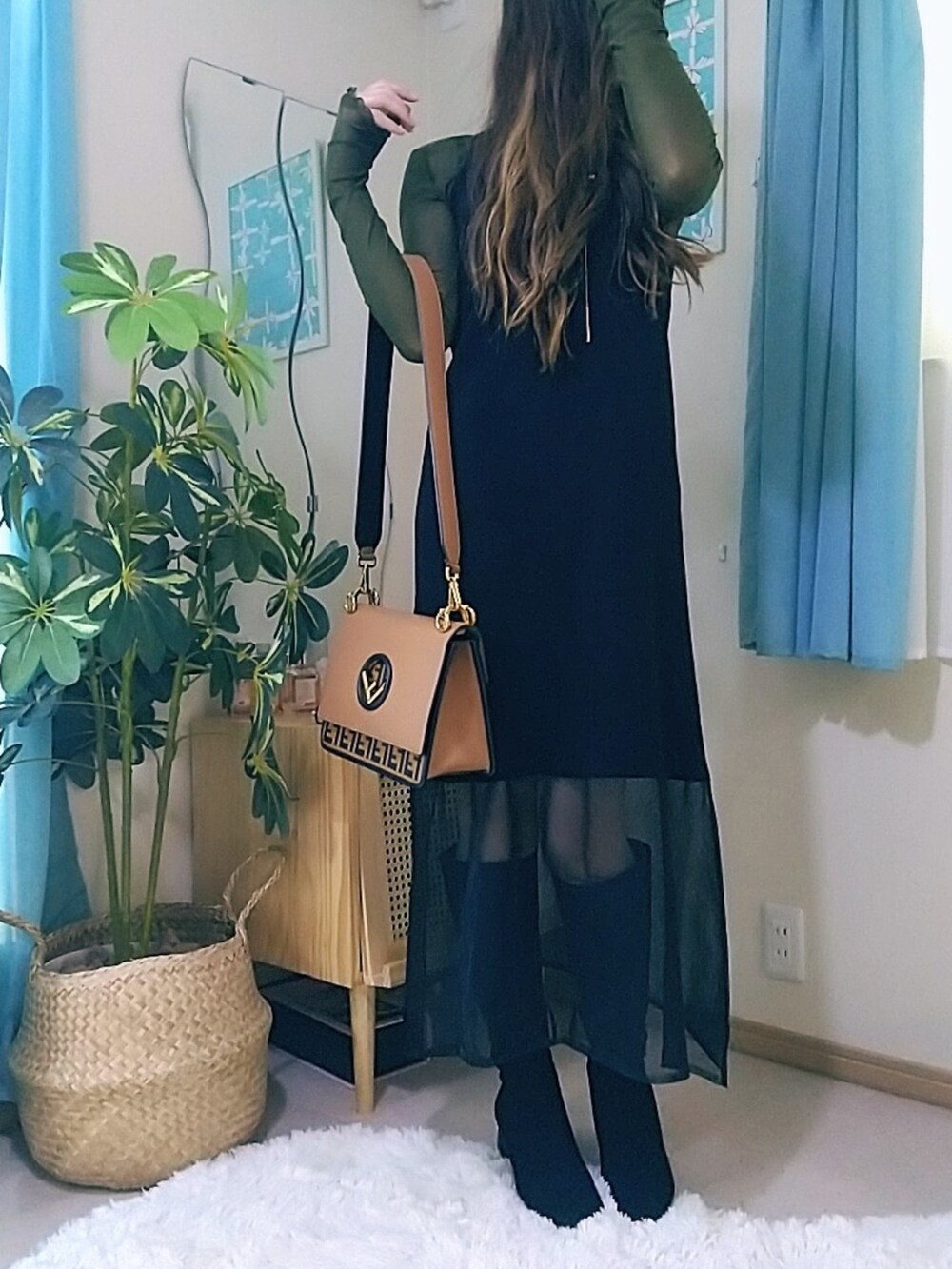 ブラック系のワンピース、ブラウン系のショルダーバッグを着用したレディースの春コーディネートの2枚目の写真