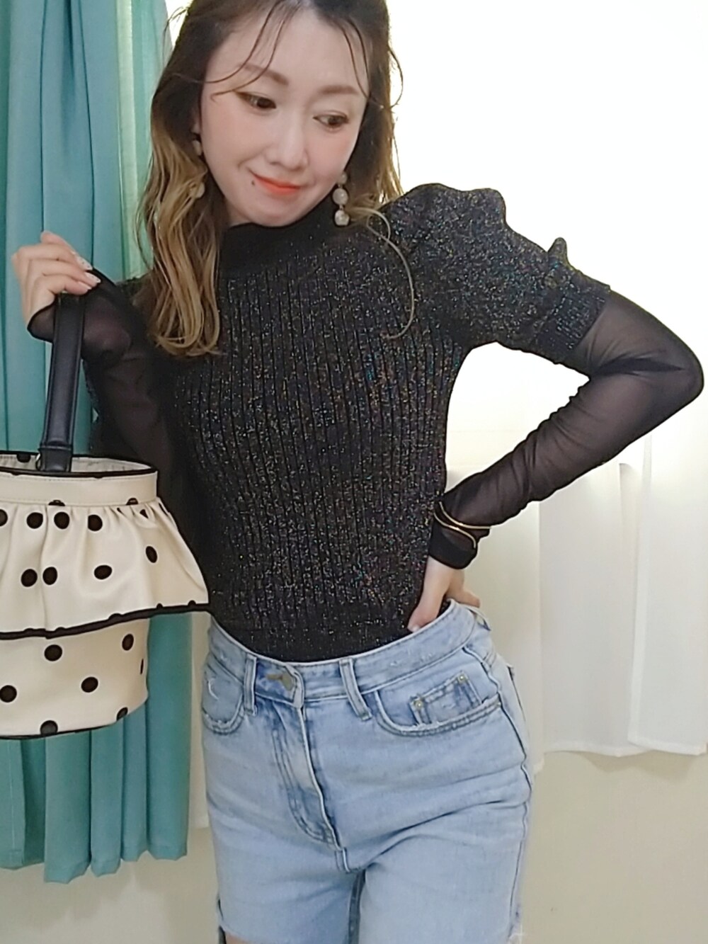 ブルー系のデニムパンツ、ブラック系のニット/セーターを着用したレディースの秋コーディネートの2枚目の写真