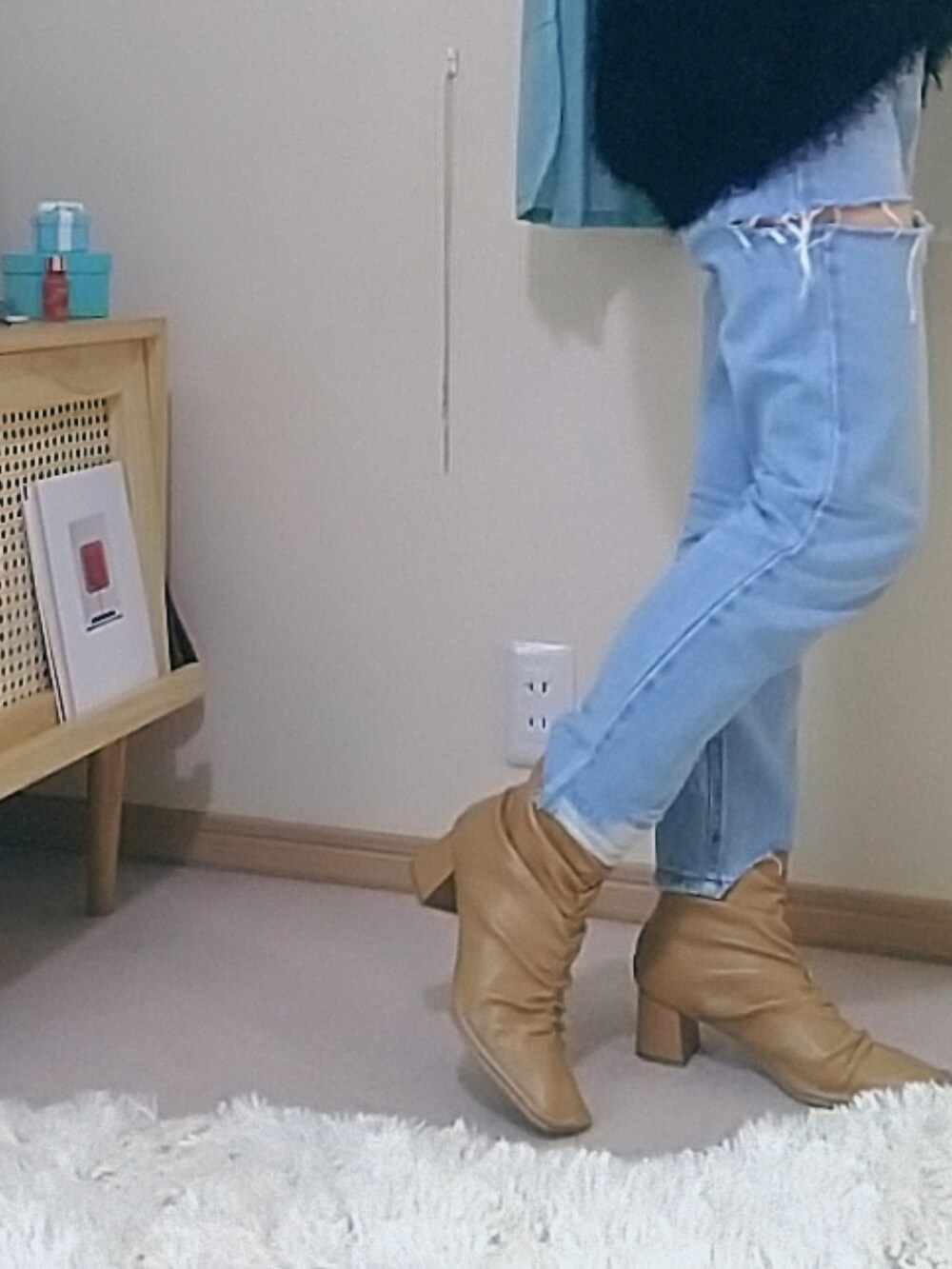 ブルー系のデニムパンツ、ブラック系のベスト、ベージュ系のブーツを着用したレディースの春コーディネートの2枚目の写真