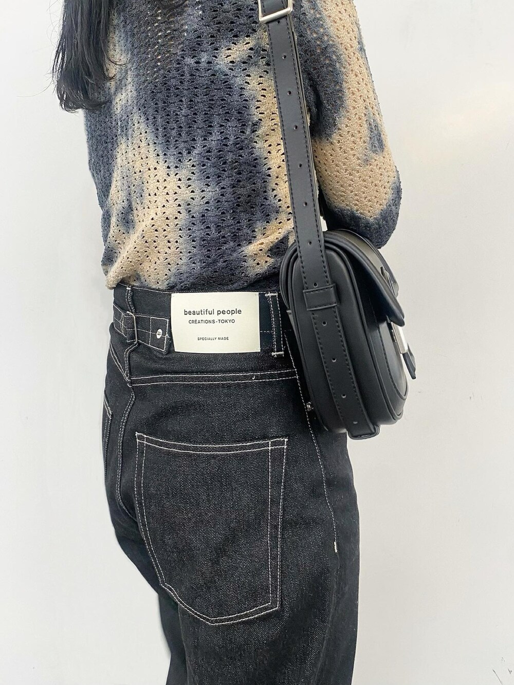 ブルー系のTシャツ/カットソー、ブラック系のショルダーバッグ、ホワイト系のスニーカーを着用したレディースの夏コーディネートの2枚目の写真