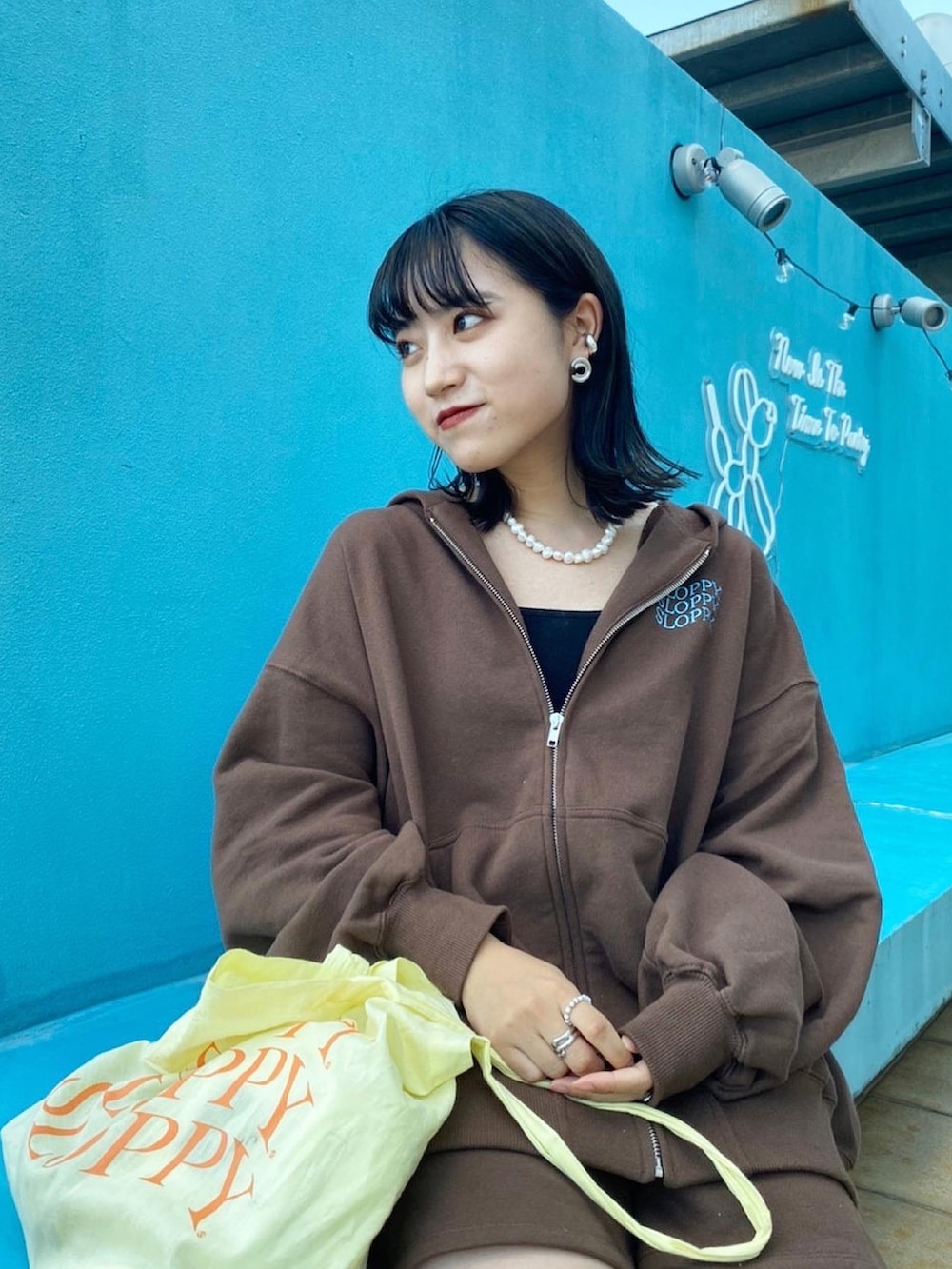 ブラウン系のパーカー、ブラウン系のスウェットパンツ、ブラック系のキャミソールを着用したレディースの秋コーディネートの2枚目の写真