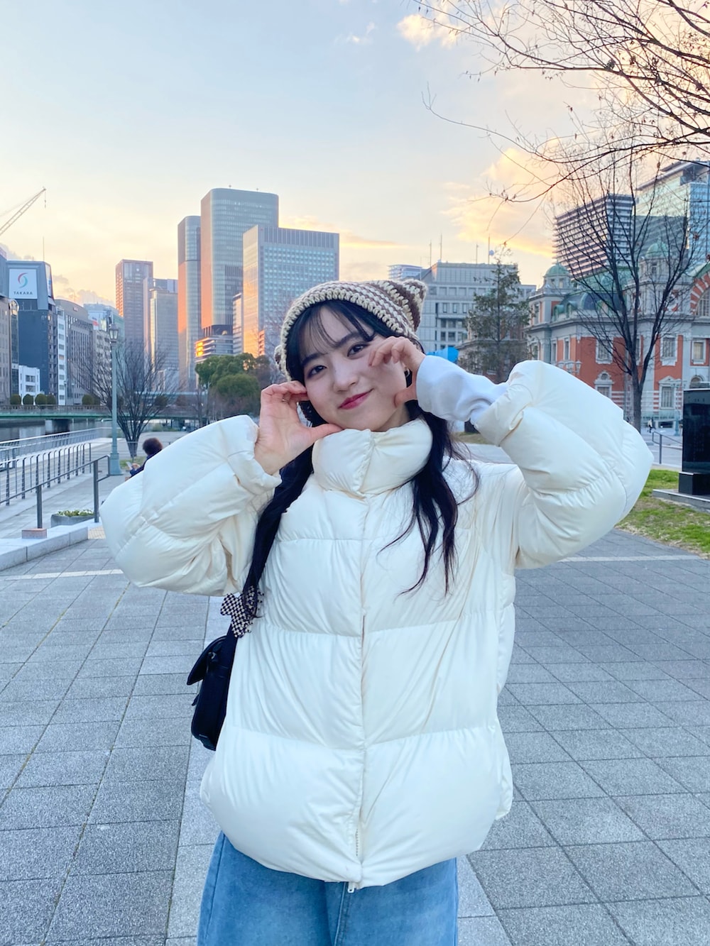 ホワイト系のダウンジャケット/コート、ブルー系のデニムスカート、ベージュ系のサンダルを着用したレディースの冬コーディネートの4枚目の写真