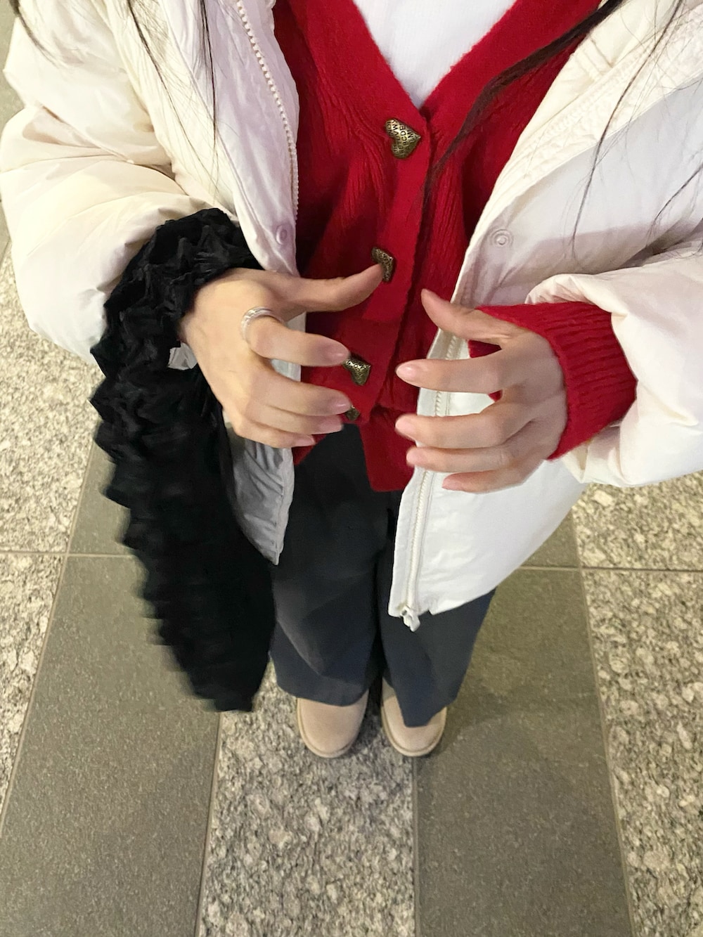 ブラック系のハンドバッグ、ベージュ系のシューズ、ホワイト系のダウンジャケット/コートを着用したレディースの冬コーディネートの2枚目の写真