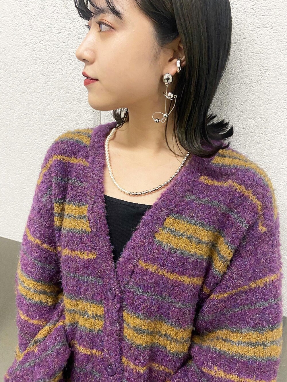 ブラック系のキャミソール、パープル系のカーディガン/ボレロ、ブルー系のデニムパンツを着用したレディースの秋コーディネートの2枚目の写真