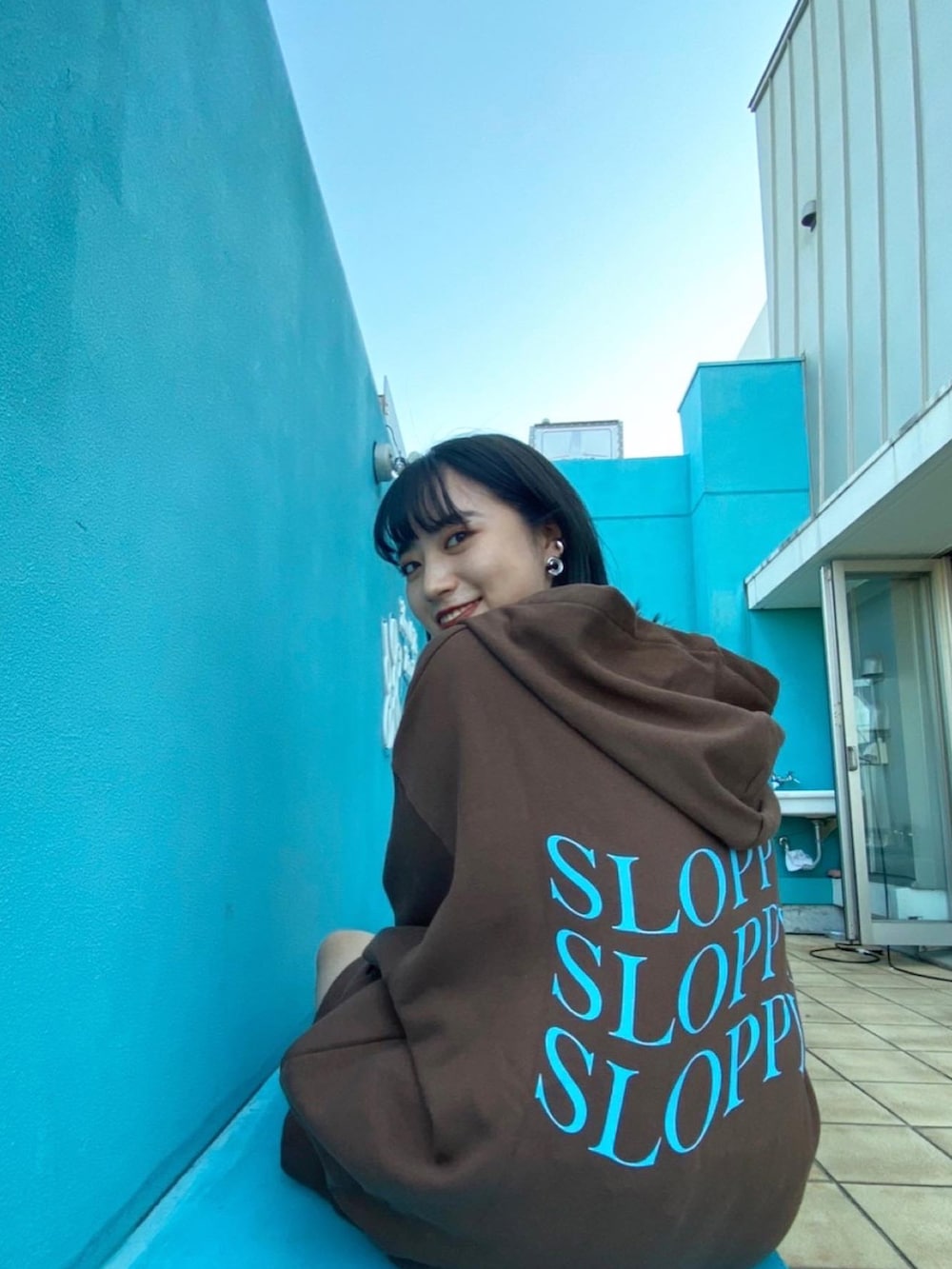 ブラウン系のパーカー、ブラウン系のスウェットパンツ、ブラック系のキャミソールを着用したレディースの秋コーディネートの3枚目の写真