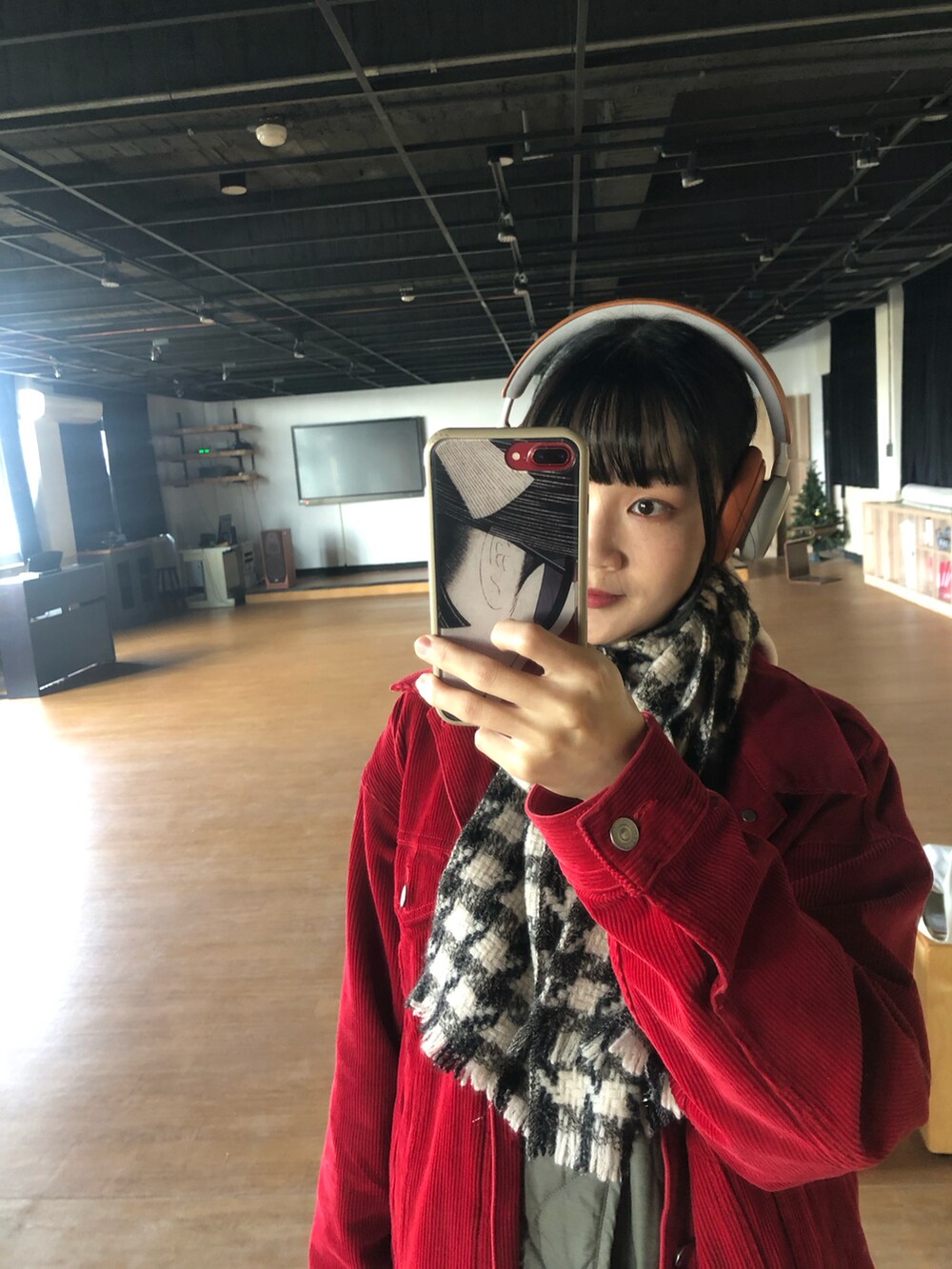 レッド系のデニムジャケット、ブラック系のその他シューズ、オレンジ系のヘッドフォン/イヤホンを着用したレディースの冬コーディネートの5枚目の写真