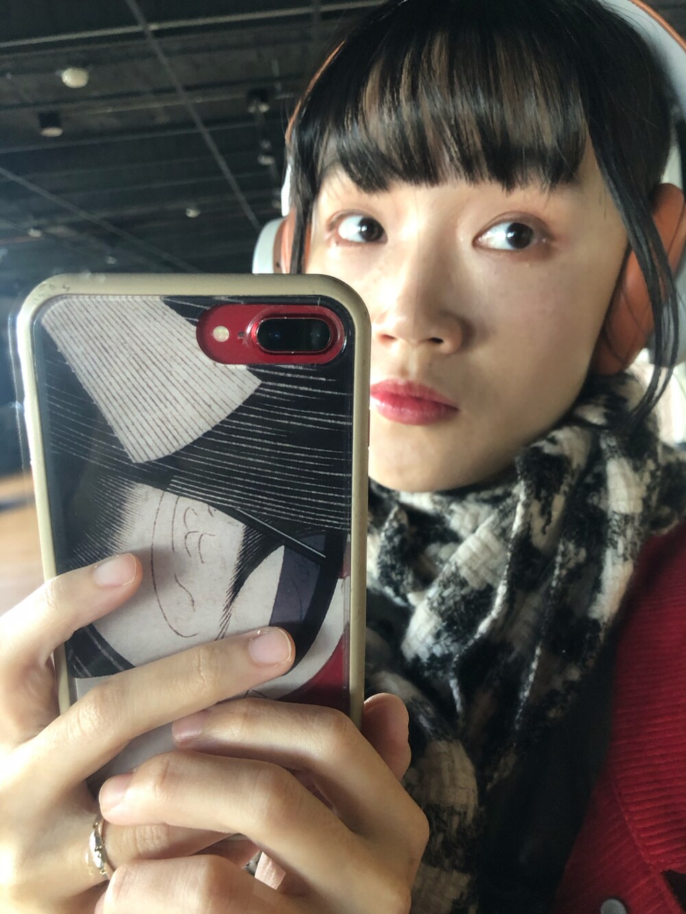 レッド系のデニムジャケット、ブラック系のその他シューズ、オレンジ系のヘッドフォン/イヤホンを着用したレディースの冬コーディネートの4枚目の写真