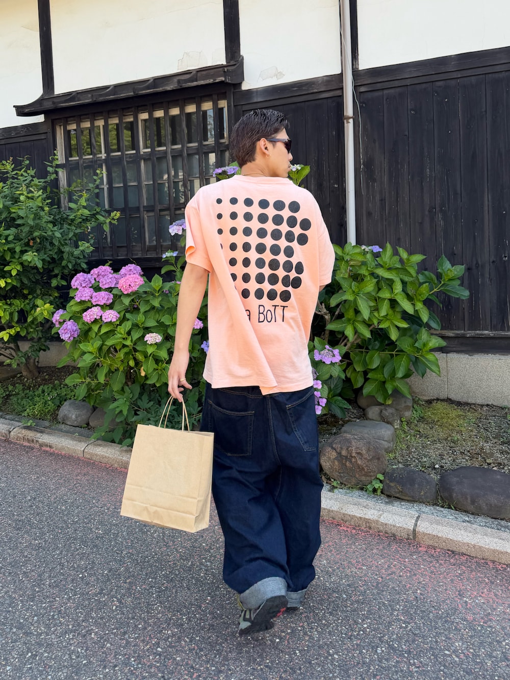 ブルー系のデニムパンツ、ピンク系のTシャツ/カットソー、ブルー系のスニーカーを着用したメンズの夏コーディネートの2枚目の写真