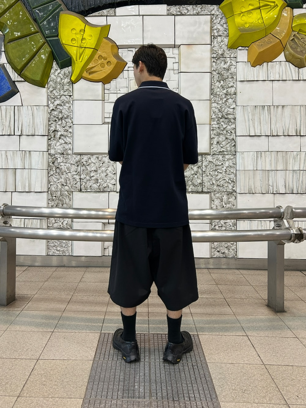 ブルー系のポロシャツ、ブラック系のパンツ、ブラック系のローファーを着用したメンズの春コーディネートの3枚目の写真