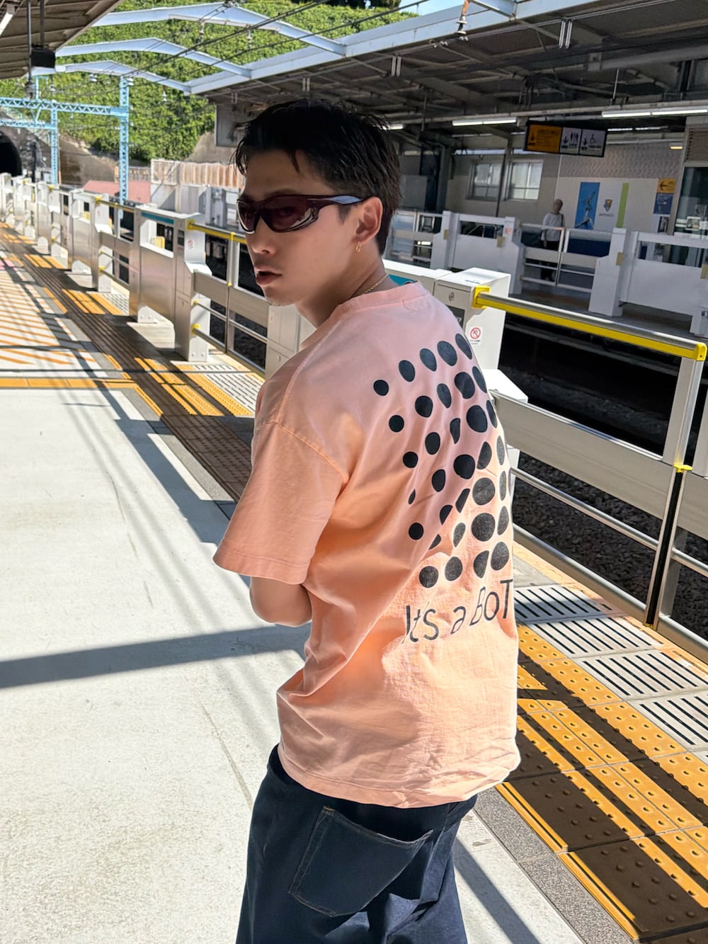 ブルー系のデニムパンツ、ピンク系のTシャツ/カットソー、ブルー系のスニーカーを着用したメンズの夏コーディネートの4枚目の写真