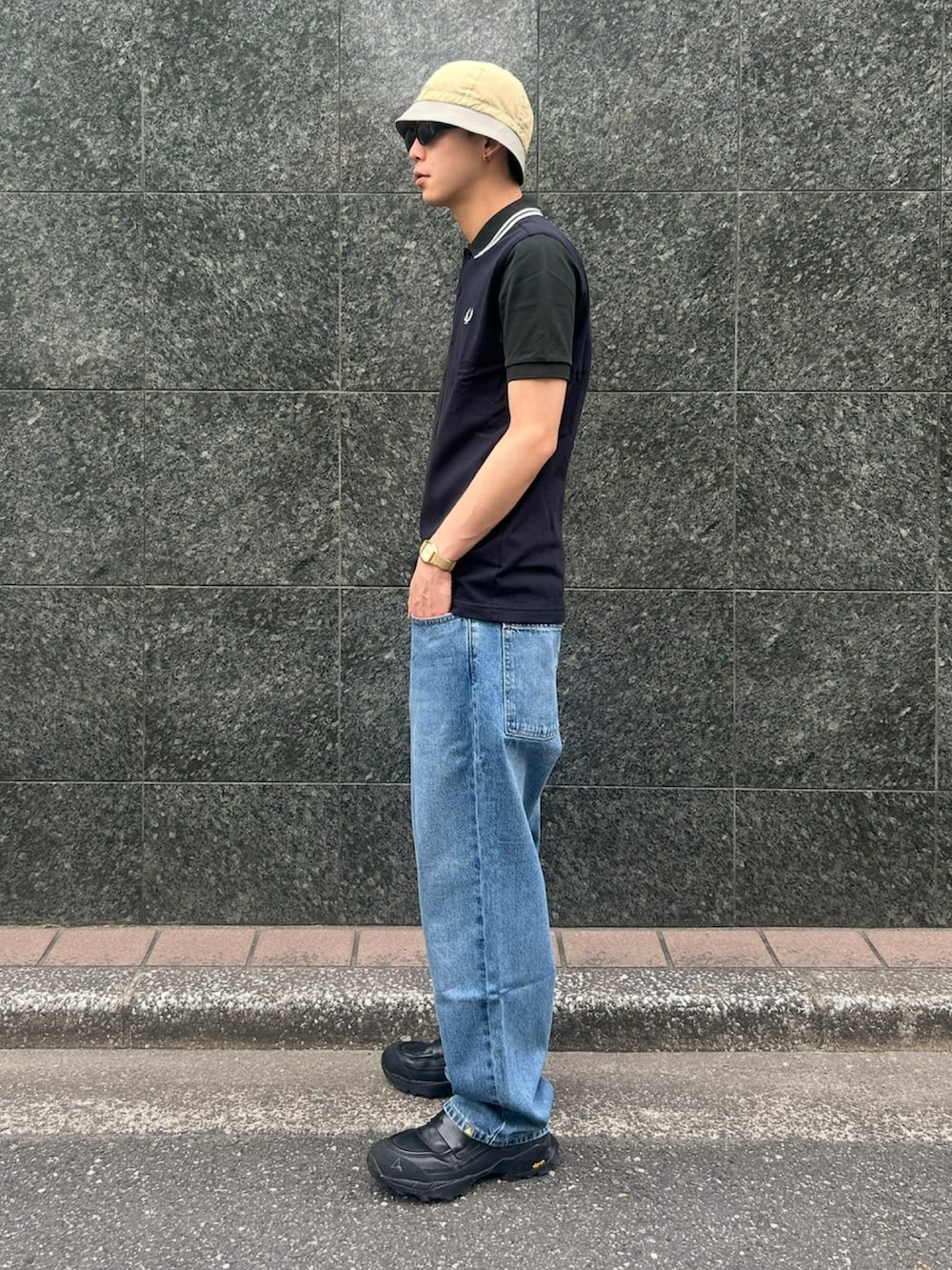 グリーン系のポロシャツ、ブルー系のデニムパンツ、ブラック系のローファーを着用したメンズの春コーディネートの4枚目の写真