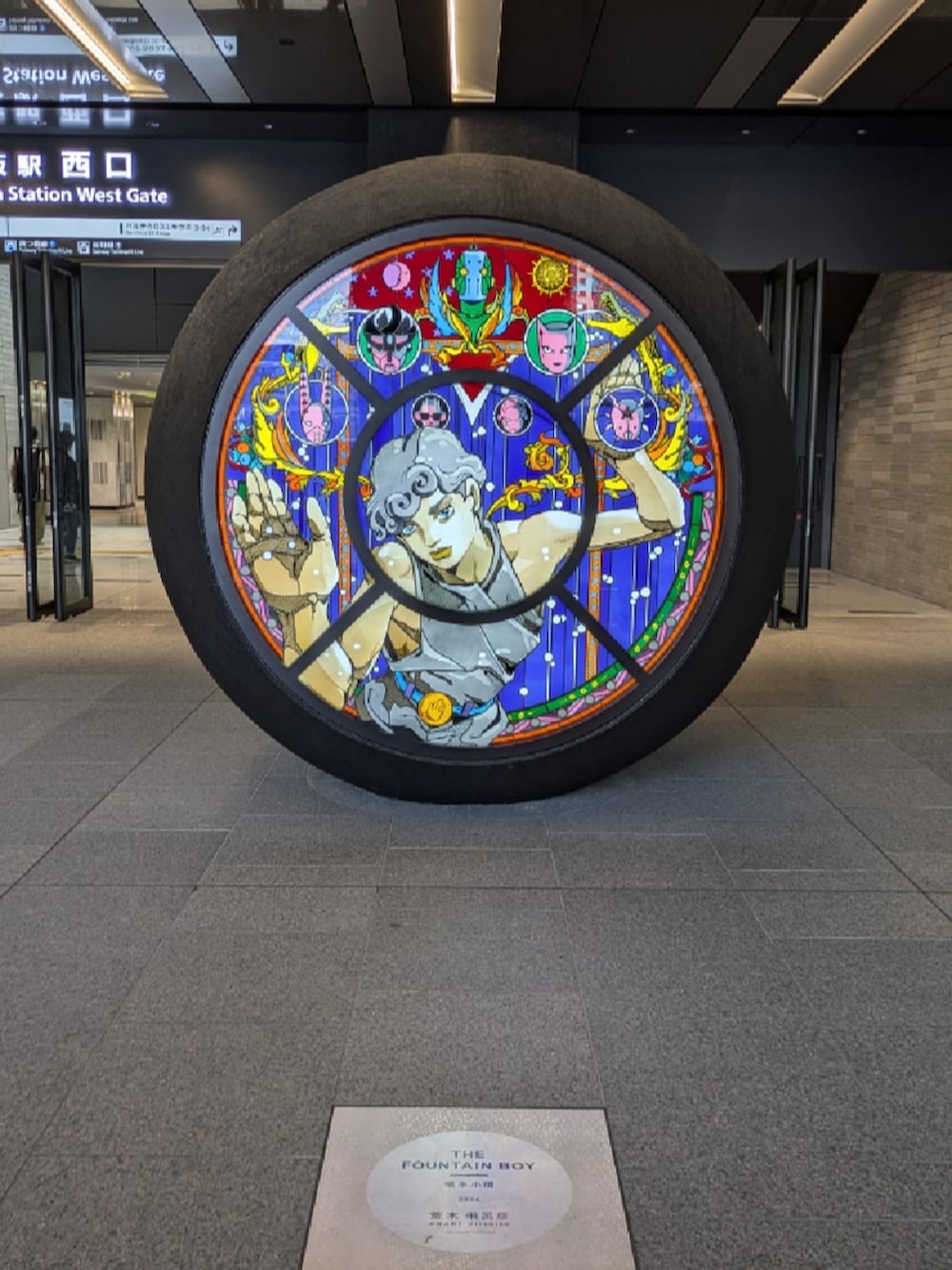 ブラック系のTシャツ/カットソー、グレー系のスラックス、ブラック系のローファーを着用したメンズの夏コーディネートの3枚目の写真