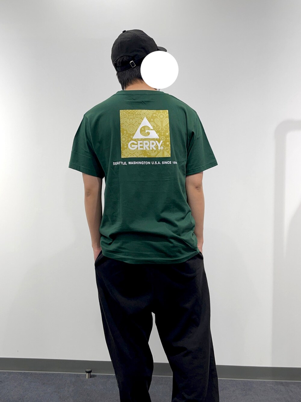 グリーン系のTシャツ/カットソー、ブラック系のカーゴパンツを着用したメンズの春コーディネートの3枚目の写真