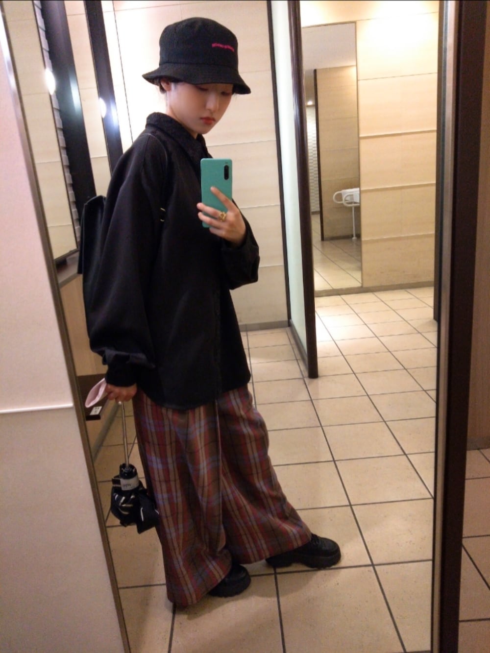 ブラック系のシャツ/ブラウス、ブラウン系のスラックス、ブラック系のバックパック/リュックを着用したレディースの秋コーディネートの2枚目の写真