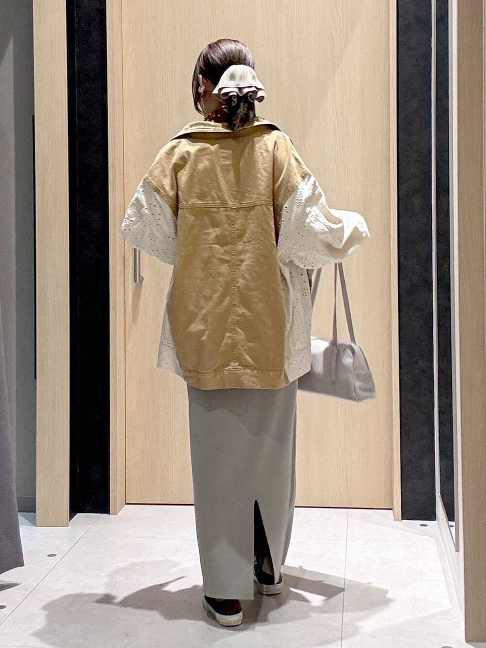 グレー系のスカート、イエロー系のスニーカー、グレー系のボストンバッグを着用したレディースの冬コーディネートの8枚目の写真