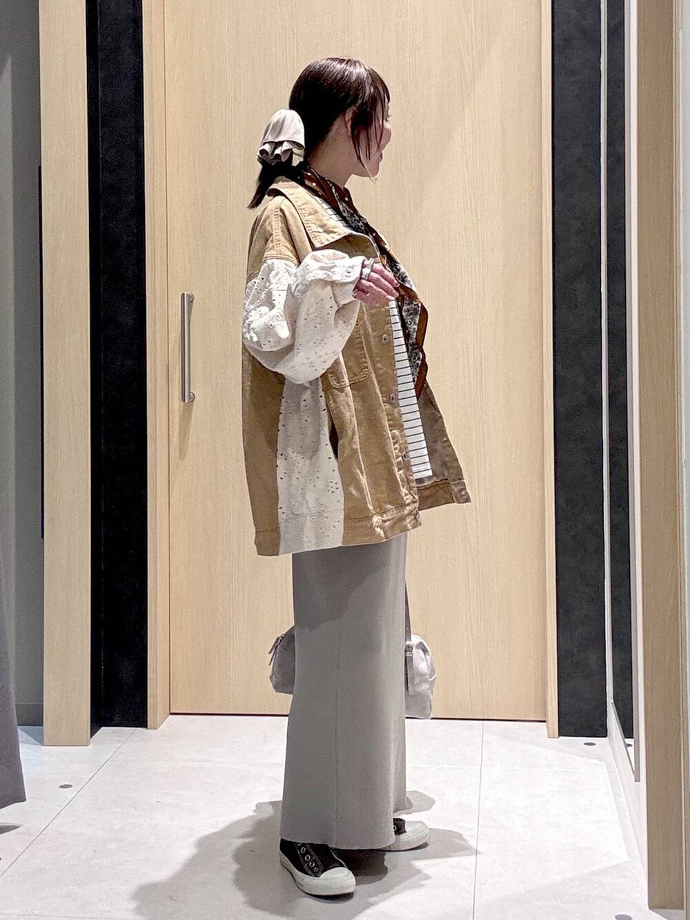 グレー系のスカート、イエロー系のスニーカー、グレー系のボストンバッグを着用したレディースの冬コーディネートの5枚目の写真