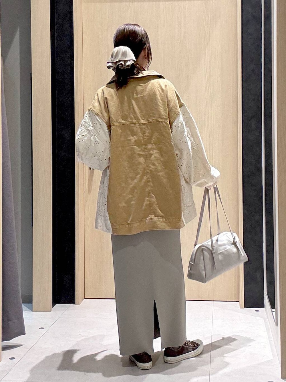 グレー系のスカート、イエロー系のスニーカー、グレー系のボストンバッグを着用したレディースの冬コーディネートの9枚目の写真