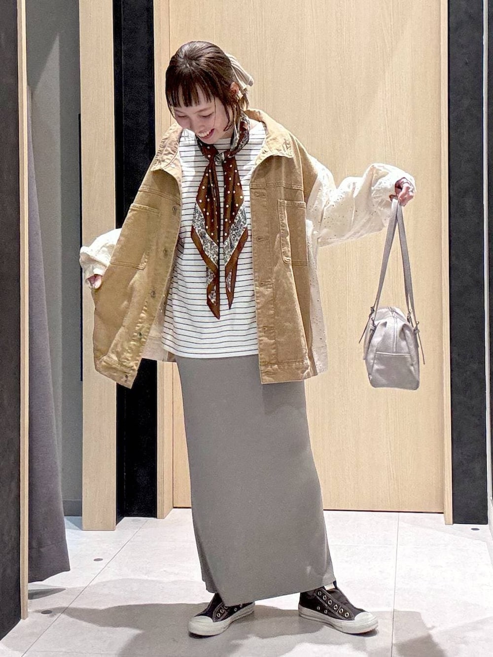 グレー系のスカート、イエロー系のスニーカー、グレー系のボストンバッグを着用したレディースの冬コーディネートの3枚目の写真