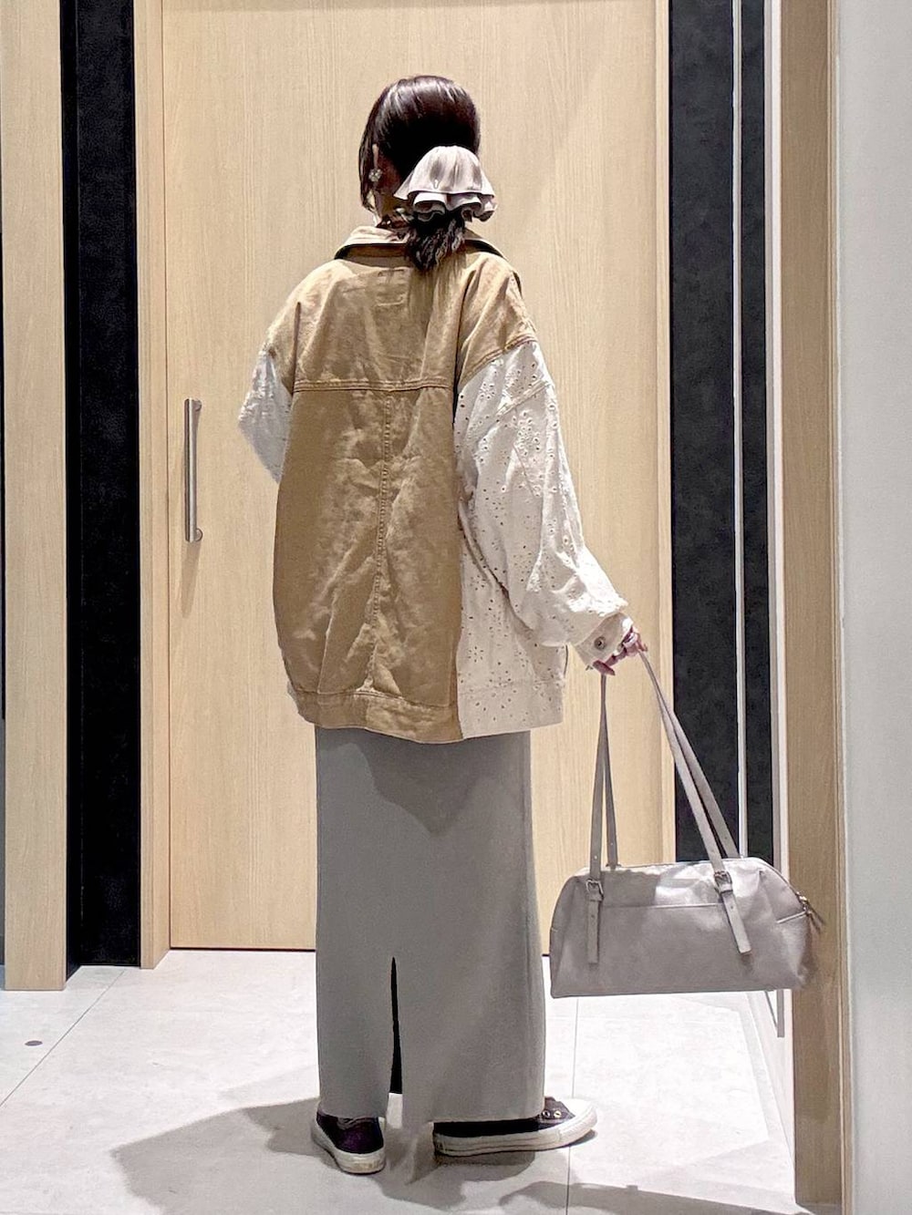 グレー系のスカート、イエロー系のスニーカー、グレー系のボストンバッグを着用したレディースの冬コーディネートの7枚目の写真