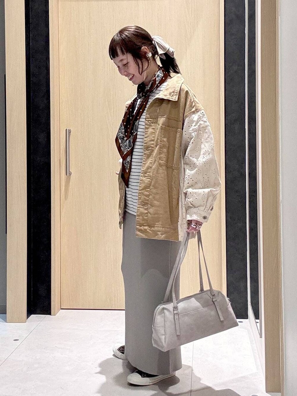 グレー系のスカート、イエロー系のスニーカー、グレー系のボストンバッグを着用したレディースの冬コーディネートの4枚目の写真