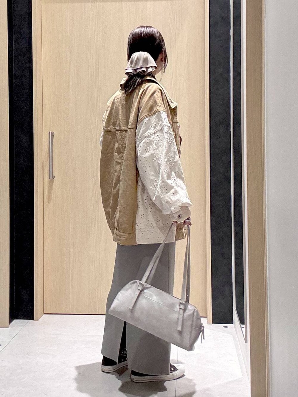 グレー系のスカート、イエロー系のスニーカー、グレー系のボストンバッグを着用したレディースの冬コーディネートの6枚目の写真