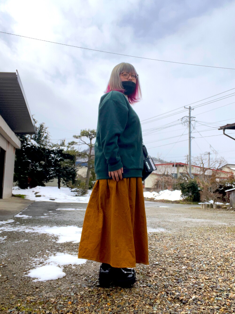 グリーン系のスウェットを着用したレディースの冬コーディネートの2枚目の写真