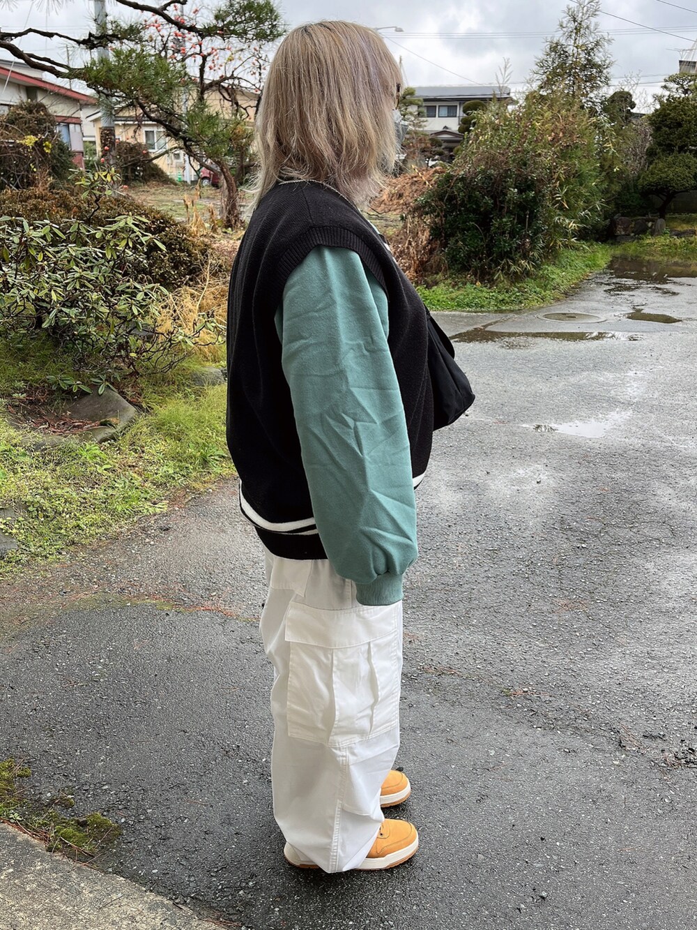 ホワイト系のパンツ、ブラック系のバッグ、ブラック系のトップスを着用したレディースの冬コーディネートの2枚目の写真