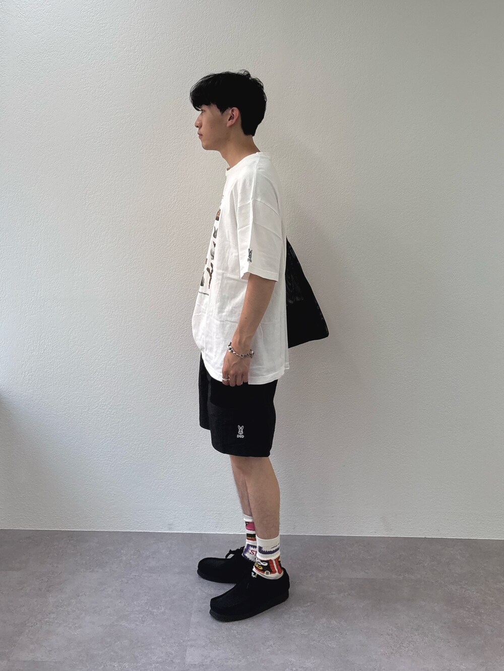 ホワイト系のTシャツ/カットソー、ブラック系のその他パンツ、ブラック系のトートバッグを着用したメンズの春コーディネートの2枚目の写真