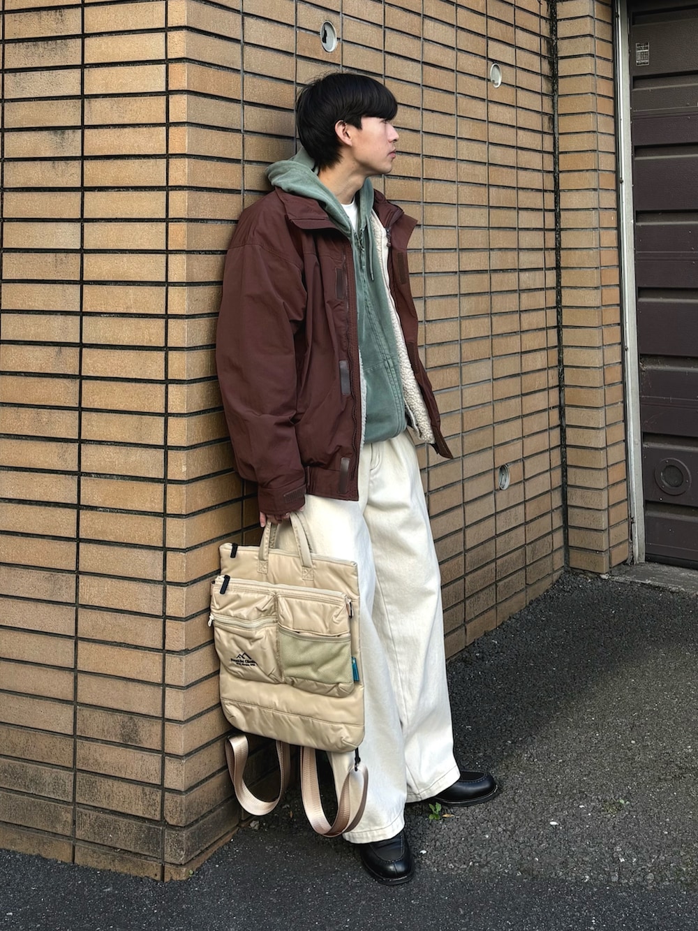 ブラウン系のナイロンジャケット、グリーン系のパーカー、ホワイト系のブルゾンを着用したメンズの冬コーディネートの2枚目の写真