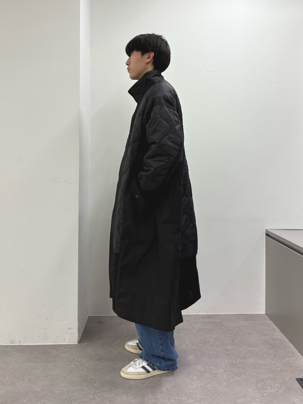 ブラック系のモッズコート、ブルー系のデニムパンツを着用したメンズの冬コーディネートの2枚目の写真